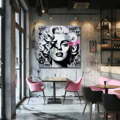 Moderan pop art portret Merilin Monro u crno-belim tonovima sa grafitima i ružičastim detaljima, okačen u stilizovanom enterijeru iznad drvene konzole sa vazom i svećom, Papilora.